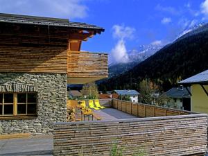 ザンクト・アントン・アム・アールベルクにあるCountry house in Sankt Anton am Arlberg with saunaの山を背景にしたデッキ(椅子付)