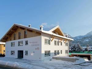 a building in the snow with mountains in the background at Modern Apartment near Ski Trail in Brixen in Feuring