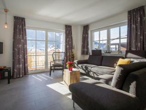 a living room with a couch and a table and windows at Modern Apartment near Ski Trail in Brixen in Feuring