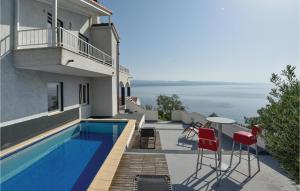 a house with a swimming pool and red chairs at Lovely Home In Stanici With House Sea View in Tice
