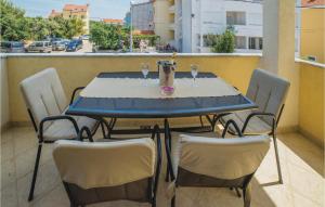 a blue table with chairs and glasses on a balcony at Pet Friendly Apartment In Biograd With Kitchen in Biograd na Moru