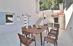 eine Terrasse mit einem Holztisch und Stühlen in der Unterkunft Awesome Home In Zedno With Outdoor Swimming Pool in Trogir