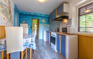 een keuken met blauwe muren en witte apparatuur bij Lovely Apartment In Omis With Kitchen in Omiš
