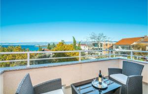 a patio with two chairs and a table on a balcony at Cozy Apartment In Njivice With Wifi in Njivice