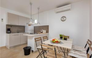 Una cocina con una mesa con un bol de fruta encima. en Gorgeous Apartment In Malinska, en Omišalj