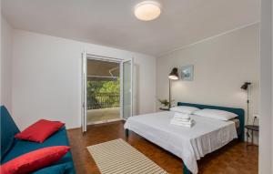 1 dormitorio con 1 cama blanca y 1 sofá azul en Gorgeous Apartment In Malinska, en Omišalj