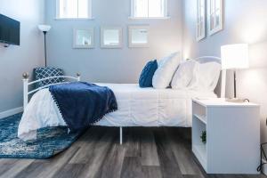 a bedroom with a white bed with blue and white pillows at Sanctuary Co 204 Loft Downtown Johnson City in Johnson City +24 photos