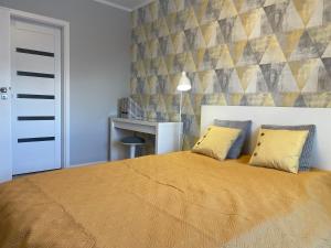 a bedroom with a bed with two yellow pillows at Apartament PARYŻ in Białystok