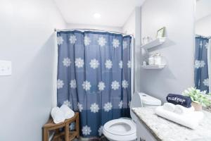 a bathroom with a blue shower curtain with snowflakes at The Sanctuary Company Johnson City in Johnson City +23 photos