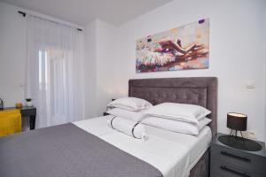 a bedroom with a bed with white sheets and pillows at Villa Sky - Heating Pool in Kastel Novi +82 photos
