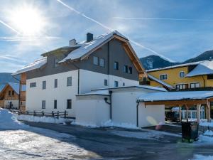 a large white building with snow on the ground at Wooden chalet in Mauterndorf near Cross Country Meadows in Mauterndorf