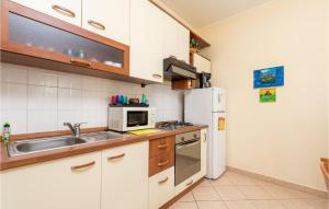 a kitchen with a sink and a white refrigerator at Nice Apartment In Opatija With House Sea View in Opatija