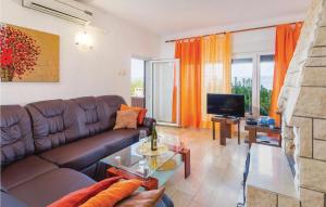 a living room with a brown leather couch and a television at Nice Apartment In Labin With Outdoor Swimming Pool in Ravni