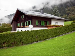 ザンクト・ガレンキルヒにあるModern Apartment in Sankt Gallenkirch with Lovely Gardenの緑の垣根のある丘の上の家