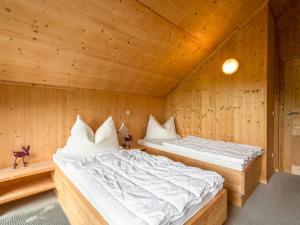 two beds in a room with wooden walls at Chalet in St Georgen ob Murau near ski area in Sankt Georgen ob Murau