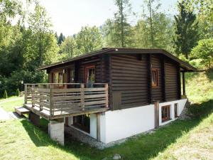 a small wooden cabin in a field with a porch at Forest chalet in Wörgl near SkiWelt Wilder Kaiser in Wörgler Boden