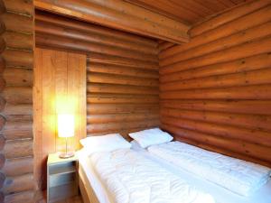 a bed in a wooden room with a lamp at Forest chalet in Wörgl near SkiWelt Wilder Kaiser in Wörgler Boden