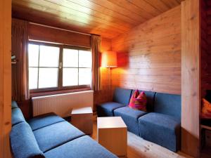 a living room with two blue couches and a window at Forest chalet in Wörgl near SkiWelt Wilder Kaiser in Wörgler Boden