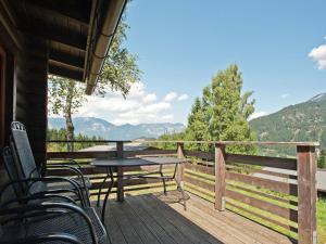 a deck with tables and chairs and a view of the mountains at Forest chalet in Wörgl near SkiWelt Wilder Kaiser in Wörgler Boden +22 photos