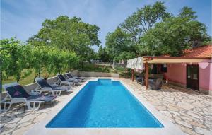 basen z leżakami obok domu w obiekcie Holiday Home Breg V w mieście Raša