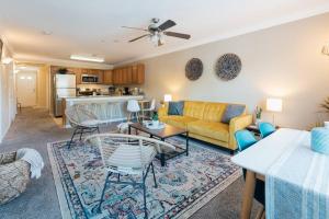 a living room with a yellow couch and a kitchen at The Sanctuary Company Johnson City in Johnson City