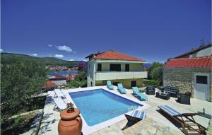 una piscina con sillas y una casa en Apartment Trogir With Sea View 06, en Trogir