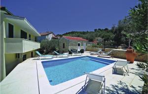una piscina con sillas y una casa en Apartment Trogir With Sea View 06, en Trogir