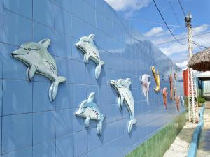 a mural of dolphins on the side of a wall at Hotel Oásis in Açu
