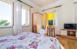 sypialnia z łóżkiem, 2 krzesłami i telewizorem w obiekcie Stunning Apartment In Lovran With Kitchen w mieście Lovran