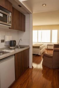 a kitchen and a living room with a bed at Suite Comfort Apartments by Time Hotel & Apartments in Santiago