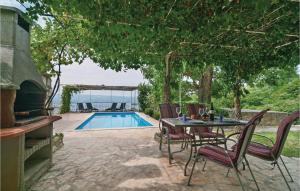 a patio with a table and chairs next to a pool at Cozy Apartment In Duce With Outdoor Swimming Pool in Duće