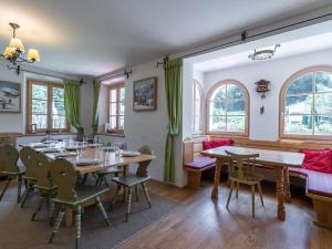 a dining room with tables and chairs and windows at Spacious Villa in Zell am See near Ski Area in Zell am See
