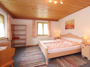 a bedroom with a large bed and a wooden ceiling at Apartment Neukirchen near Ski Slopes in Neukirchen am Großvenediger