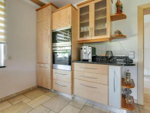 a kitchen with wooden cabinets and appliances at Holiday home in Carinthia near Lake Woerthersee in Köttmannsdorf