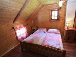 ein Schlafzimmer mit einem Bett in einem Blockhaus in der Unterkunft Chalet in Obervellach in Carinthia in Obervellach