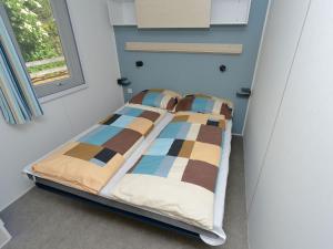 a bed in a small room with a window at Mobile home in Sachsenburg Carinthia with pool in Sachsenburg