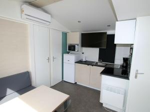 a small kitchen with white cabinets and a microwave at Mobile home in Sachsenburg Carinthia with pool in Sachsenburg
