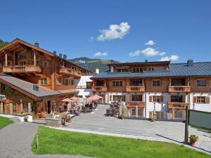 un grupo de edificios de madera con un patio en la parte delantera en Apartment near the ski area in Mittersill, en Hollersbach im Pinzgau