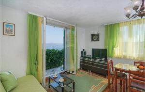un soggiorno con tende verdi e un tavolo con TV di Beautiful Home In Rogac With House Sea View a Rogač