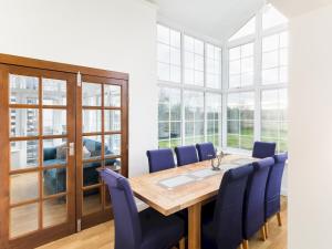 uma sala de jantar com uma mesa de madeira e cadeiras azuis em Pass the Keys SPACIOUS Modern 5 Bed, Sleeps up to 12 & Parking em Warwick