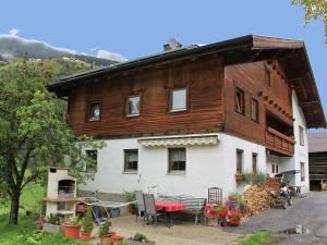 ゼーにあるApartment near the ski area in seaのテーブルと椅子付きの大きな木造家屋