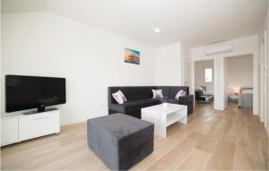 - un salon avec un canapé noir et une télévision dans l'établissement Nice Apartment In Trogir With Kitchen, à Trogir