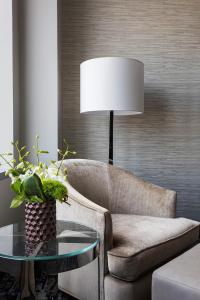 a living room with a chair and a table with a lamp at InterContinental New York Times Square by IHG in New York