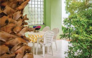 een tafel en stoelen in een kamer met een raam bij Gorgeous Apartment In Rabac With Kitchen in Rabac