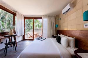 um quarto com uma cama grande e uma varanda em Mi Amor Boutique Hotel-Adults Only em Tulum