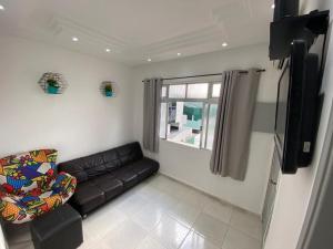 - un salon avec un canapé et une télévision dans l'établissement Lindo apartamento na Ponta da Praia, em Santos :), à Santos