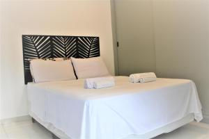 - un lit blanc avec 2 serviettes dans l'établissement Lindo apartamento na Ponta da Praia, em Santos :), à Santos