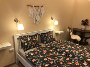 1 dormitorio con 1 cama con edredón y almohadas de flores en 21 és fél Fenyő Vendégház, en Matraszentlaszlo