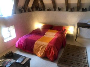 ein Schlafzimmer mit einem Bett mit einer bunten Decke in der Unterkunft Art en Célé-chambres d'hôtes in Corn