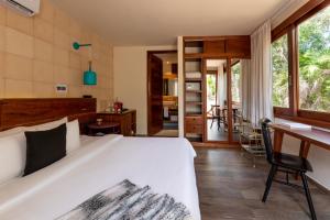 a bedroom with a large white bed and a desk at Mi Amor Boutique Hotel-Adults Only in Tulum